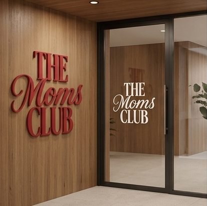 Letreiro The Moms Club em parede de madeira